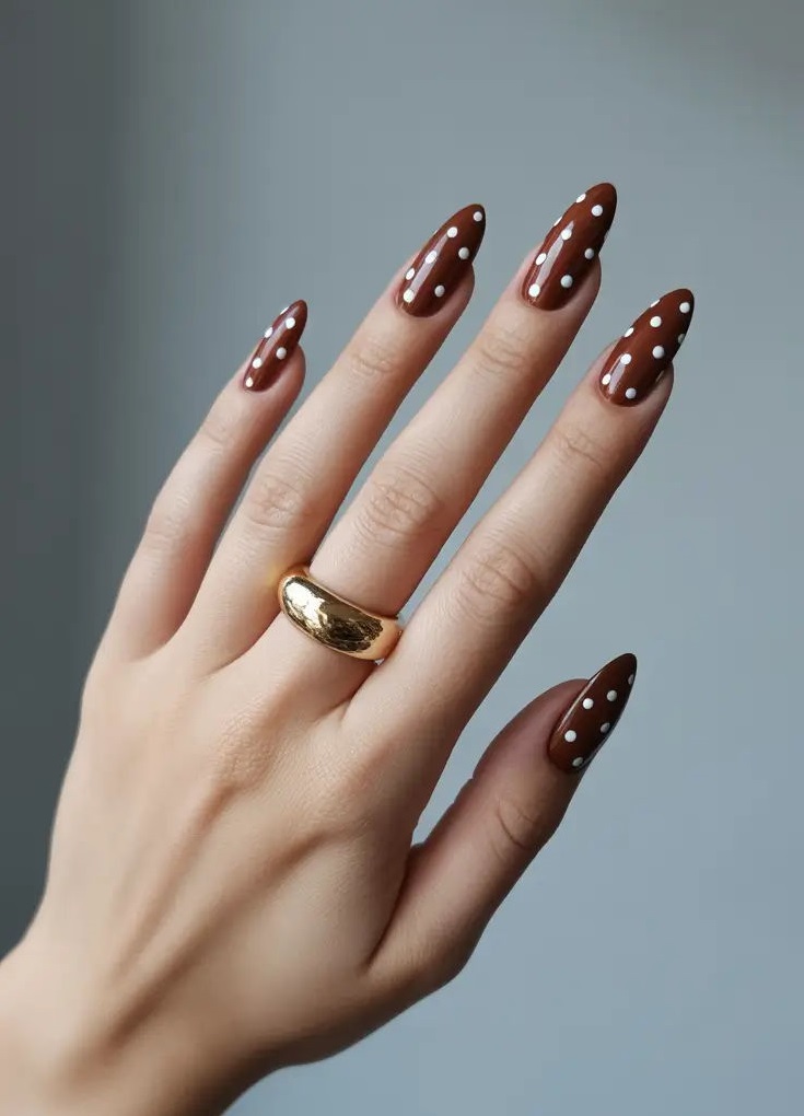 دیزاین ناخن قهوه‌ای با خال خالی های سفید 