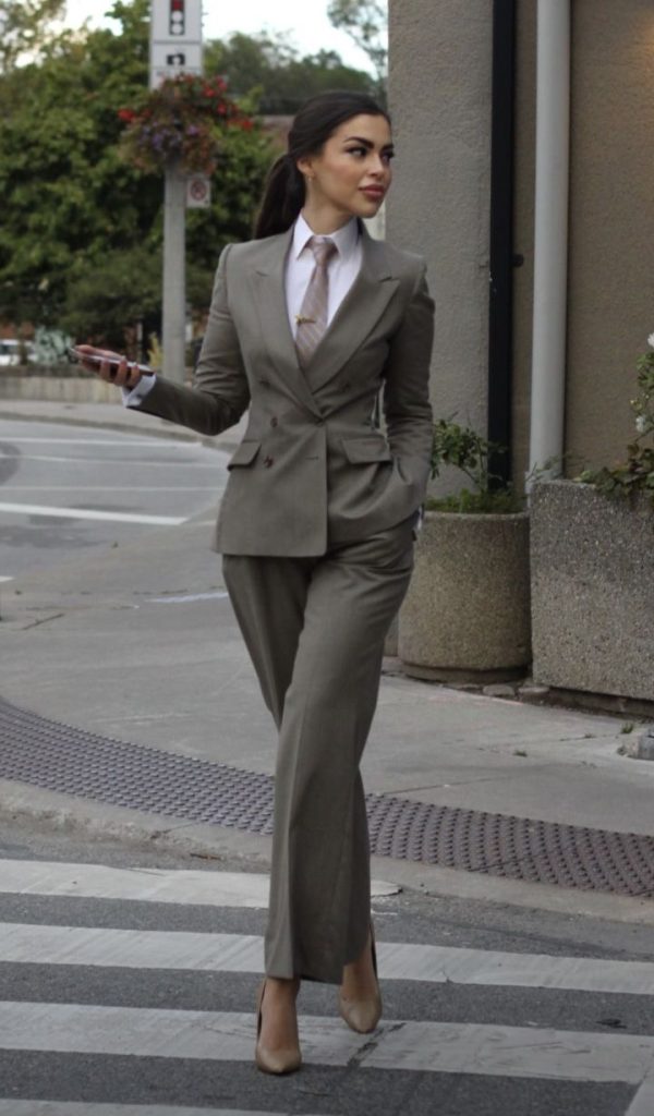 زن زیبا و جذاب با کت و شلوار طوسی
